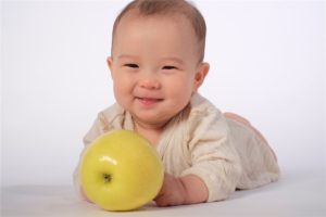 黄色のりんごと微笑む赤ちゃん